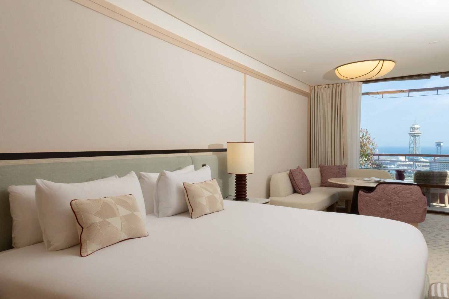 Cama King size en la Junior Suite con lencería de alta calidad y ambiente acogedor.